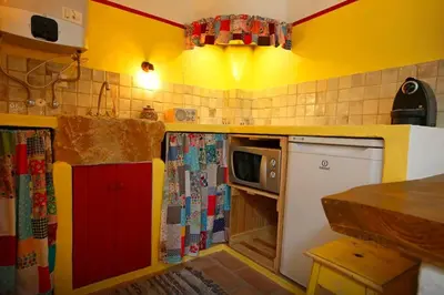 a kitchen with yellow and red walls and a microwave at Casa Amado, Aldeia da Pedralva in Vila do Bispo