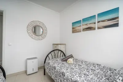 a bedroom with a bed and a mirror on the wall at Vista Mar - Burgau in Burgau