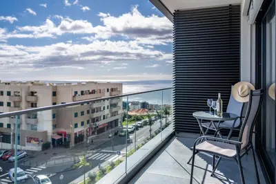 a balcony with a table and a view of a city at Fenix Ocean View by Homie in Funchal