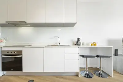 a kitchen with white cabinets and a sink at Fenix Ocean View by Homie in Funchal