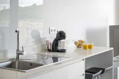a kitchen counter with a sink and two glasses of orange juice at Fenix Ocean View by Homie in Funchal