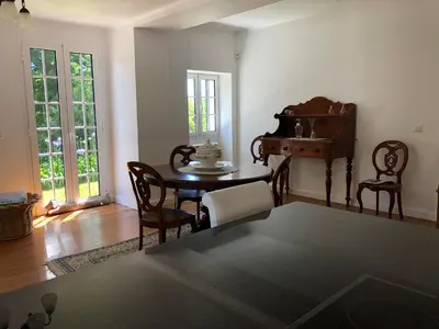 a living room with a table and chairs and a piano at Villa-sleeps2-garden-private park in Camacha
