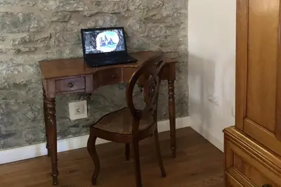 a wooden desk with a laptop computer on top of it at Villa-sleeps2-garden-private park in Camacha