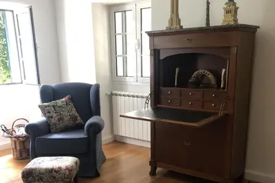 a room with a chair and a dresser with a fireplace at Villa-sleeps2-garden-private park in Camacha