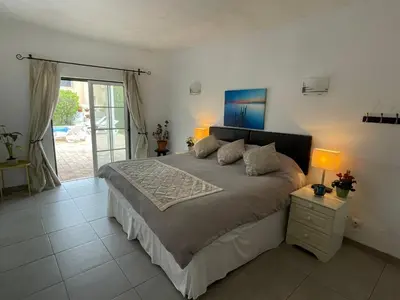 a bedroom with a large bed with two lamps at Spacious 3 bedroom villa with pool in Luz