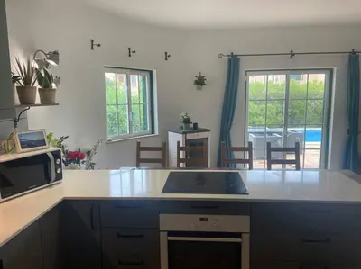 a kitchen with a counter top and a microwave at Spacious 3 bedroom villa with pool in Luz