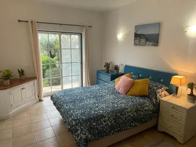 a bedroom with a bed and a large window at Spacious 3 bedroom villa with pool in Luz