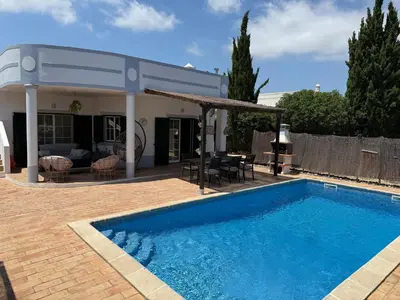 a swimming pool in front of a house at Spacious 3 bedroom villa with pool in Luz