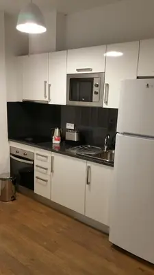 a kitchen with white cabinets and a white refrigerator at Edificio Charles 101 in Funchal