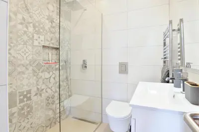 a bathroom with a shower and a toilet and a sink at Casa Rujo - Waterside Village House in Luz
