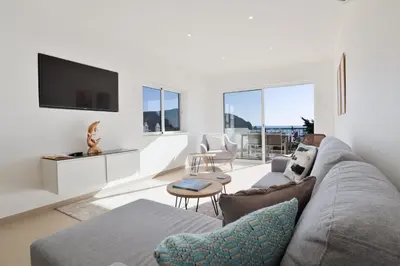 a living room with a couch and a tv at Casa Rujo - Waterside Village House in Luz