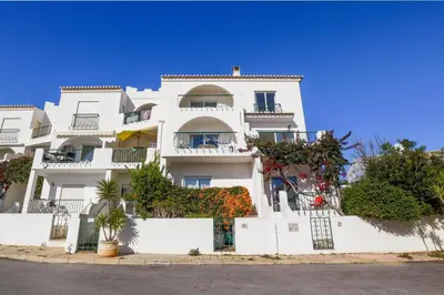 a white building with balconies and plants at Casa Rujo - Waterside Village House in Luz