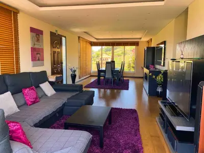 a living room with a couch and a tv and a table at Brazão Guest House in Santana