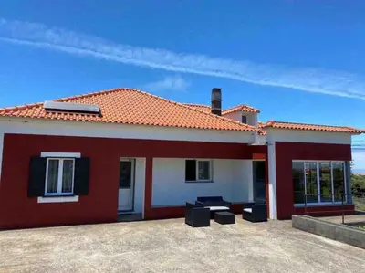 a red and white house with a patio at Brazão Guest House in Santana