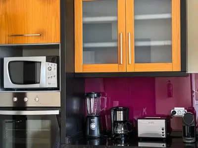 a kitchen counter with a blender and a microwave at Brazão Guest House in Santana