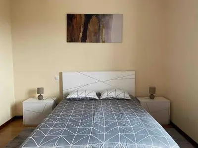 a bedroom with a bed with two nightstands and a painting at Brazão Guest House in Santana