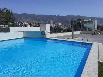 a large blue swimming pool on top of a building at Madeira Inn Group in Funchal