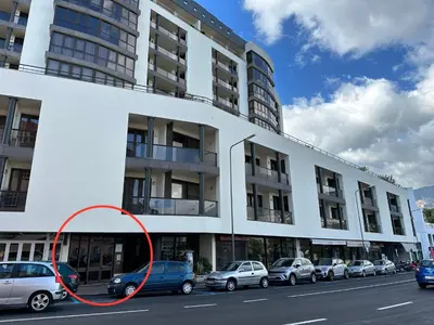 a large white building with cars parked in front of it at Madeira Inn Group in Funchal