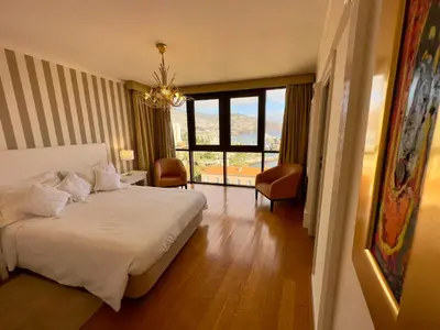 a bedroom with a white bed and a large window at Madeira Inn Group in Funchal