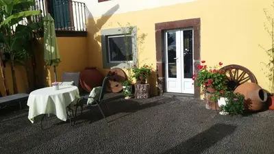 a patio with a table and chairs and flowers at Romantic Studio in Funchal