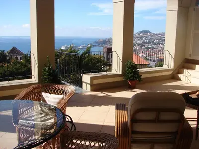 a balcony with a glass table and chairs with a view at Romantic Studio in Funchal