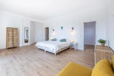 a large white bedroom with a bed and a couch at Fortaleza sea view Villa Miramar - Apartment with private pool in Budens