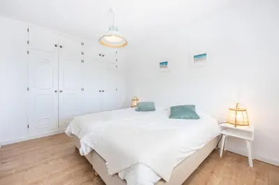 a white bedroom with a bed and a lamp at Fortaleza sea view Villa Miramar - Downstairs Apartment in Burgau