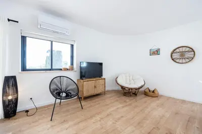 a living room with a television and a chair at Fortaleza sea view Villa Miramar - Downstairs Apartment in Burgau