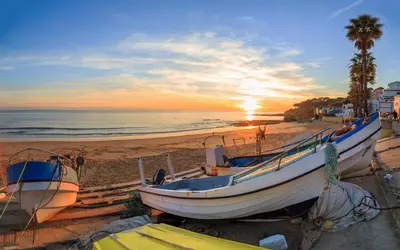 a group of boats on the beach at sunset at Fortaleza sea view Villa Miramar - Downstairs Apartment in Burgau