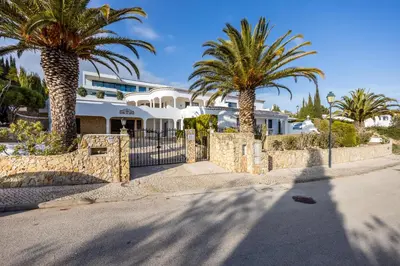 a house with palm trees in front of it at Fortaleza sea view Villa Miramar - Downstairs Apartment in Burgau