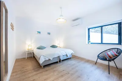 a white bedroom with a bed and a window at Fortaleza sea view Villa Miramar - Downstairs Apartment II in Burgau