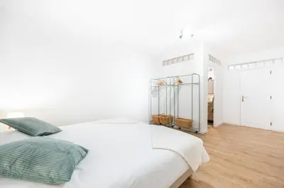 a white bedroom with a large white bed with green pillows at Fortaleza sea view Villa Miramar - Downstairs Apartment II in Burgau