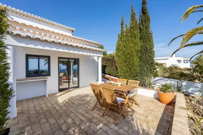 a patio with a wooden table and chairs at Fortaleza sea view Villa Miramar - Downstairs Apartment II in Burgau