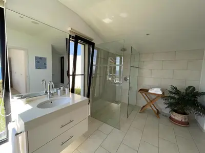 a bathroom with a sink and a glass shower at Morning Star Villa in Arco da Calheta
