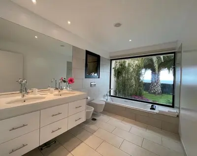 a bathroom with two sinks and a large window at Morning Star Villa in Arco da Calheta