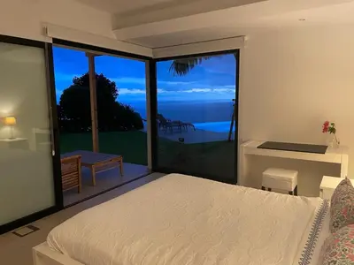 a bedroom with a bed and a view of the ocean at Morning Star Villa in Arco da Calheta