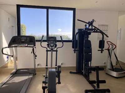 a gym with cardio machines and a large window at Morning Star Villa in Arco da Calheta