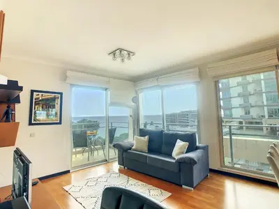 a living room with a blue couch and large windows at Rodamar Apartment by LovelyStay in Funchal