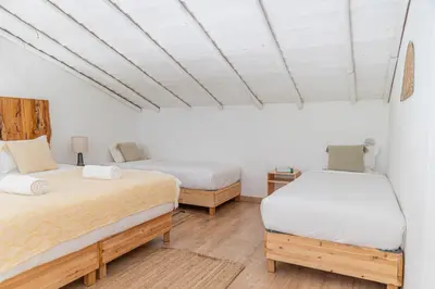two beds in a room with white walls at Casa Nook Sagres in Vila do Bispo
