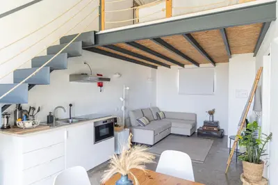 an open kitchen and living room with a staircase at Casa Nook Sagres in Vila do Bispo