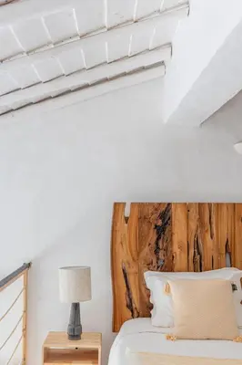a bedroom with a bed with a wooden headboard at Casa Nook Sagres in Vila do Bispo