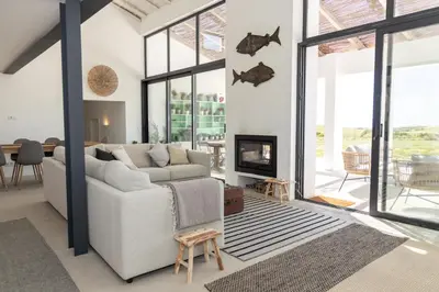 a living room with a couch and a fireplace at Casa Nook Sagres in Vila do Bispo