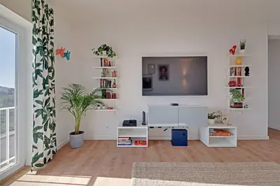 a living room with a flat screen tv on a white wall at Sea Salt, Sagres Apartment in Sagres