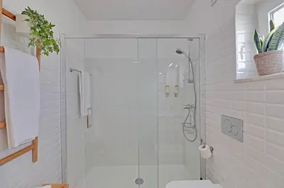 a bathroom with a glass shower with a toilet at Sea Salt, Sagres Apartment in Sagres