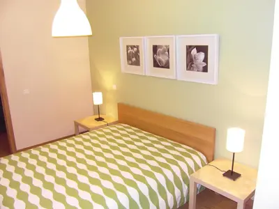 a bedroom with a bed and two tables with lamps at Anadia Chic Apartment in Funchal
