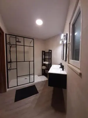a bathroom with a white sink and a window at Family House in Vila do Bispo