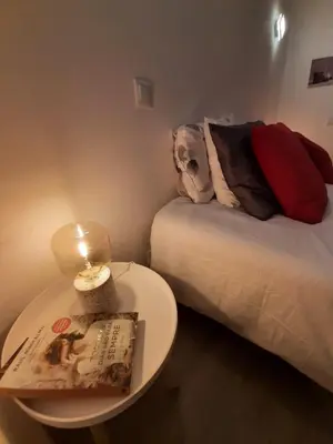 a small room with a bed and a table with a book at Family House in Vila do Bispo