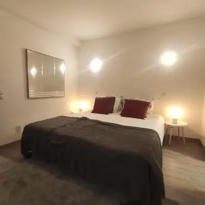 a bedroom with a large bed with two lamps at Family House in Vila do Bispo