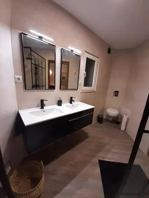 a bathroom with a sink and a mirror and a toilet at Family House in Vila do Bispo