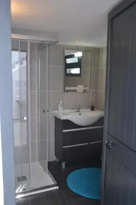 a bathroom with a sink and a glass shower at Casa d' Avó Zeza in Jardim do Mar